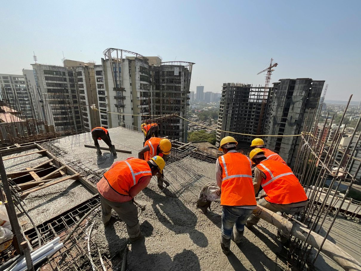 Construction crew pouring concrete on a high-rise slab
